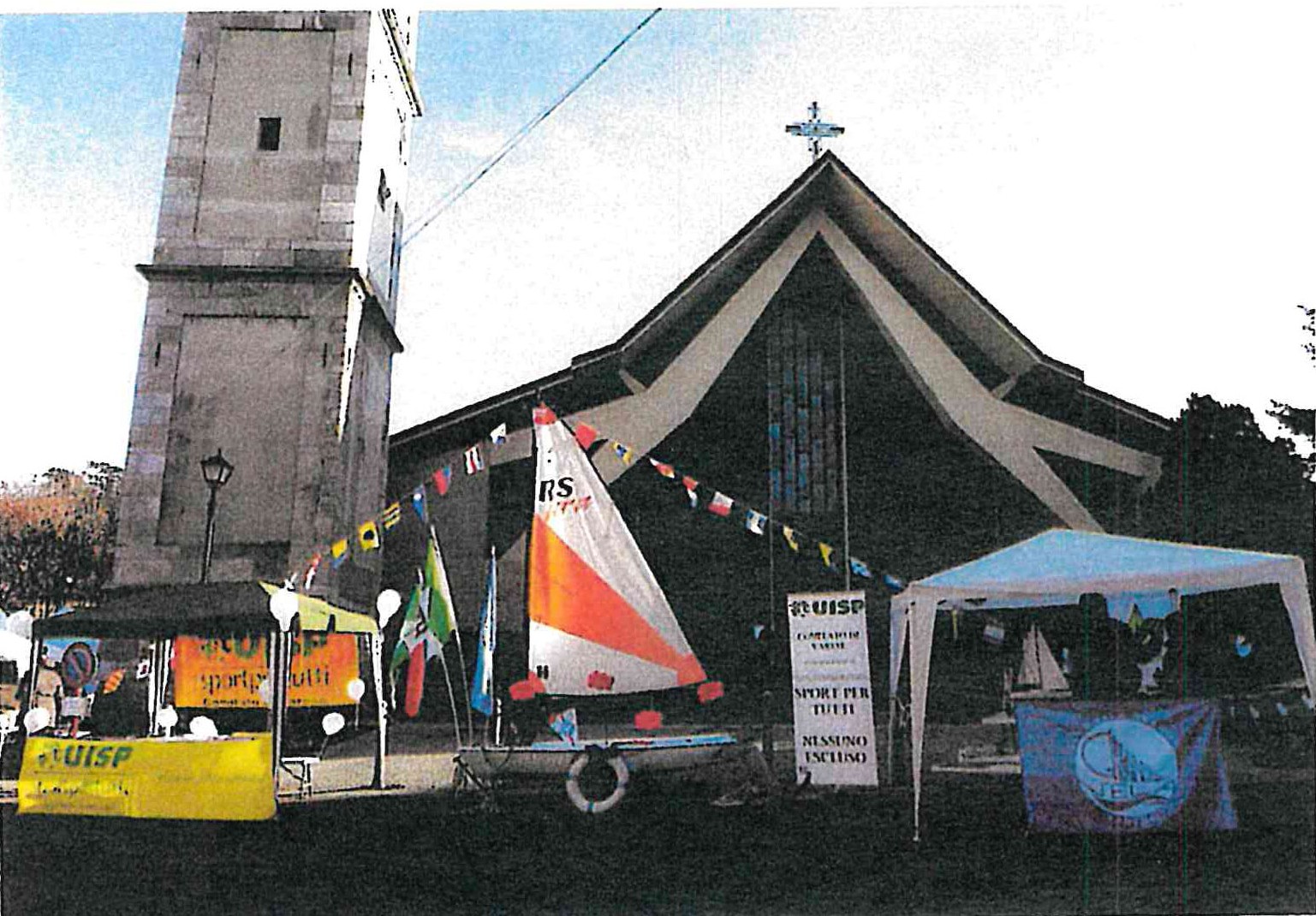Piccola barca a vela esposta davanti alla chiesa di Masnago con lo striscione Uisp durante il mercatino di Natale